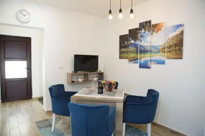 a dining room with a table and blue chairs at Dvori Sky View E13 Kopaonik - free private parking in Kopaonik