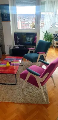 a living room with two chairs and a table at Happy Place in Niš