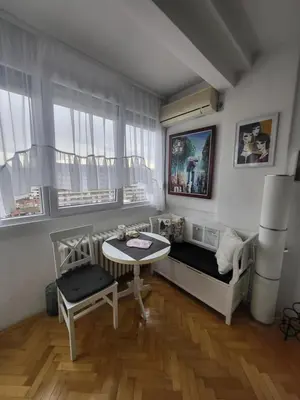 a small room with a bed and a table and window at Happy Place in Niš