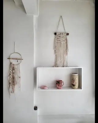 a white shelf in a white wall with a dream catcher at Happy Place in Niš