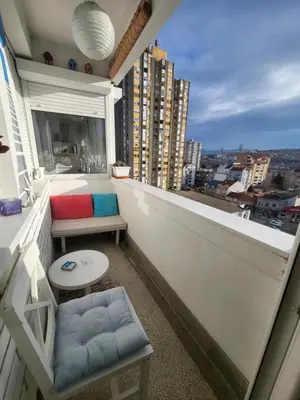 a balcony with a bench and a table and a window at Happy Place in Niš