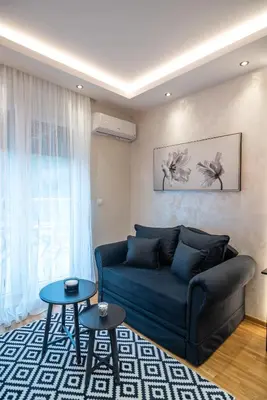 a living room with a blue couch and two tables at Zvezda Lux in Vrnjačka Banja