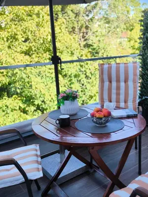 a wooden table with a bowl of fruit on a porch at Zvezda Lux in Vrnjačka Banja