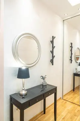 a table with a lamp and a mirror on a wall at Zvezda Lux in Vrnjačka Banja