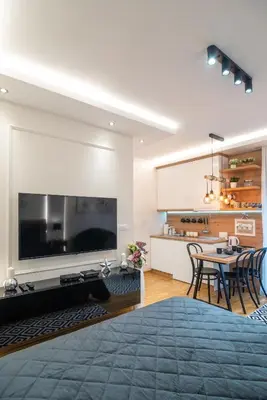 a living room with a large television and a table at Zvezda Lux in Vrnjačka Banja