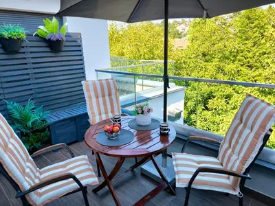 a patio with a table and two chairs and an umbrella at Zvezda Lux in Vrnjačka Banja