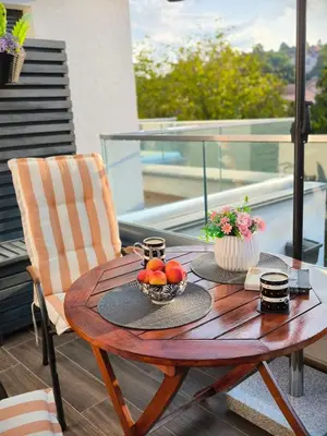 a wooden table with a bowl of fruit on a balcony at Zvezda Lux in Vrnjačka Banja