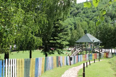 a colorful fence with a playground in a park at Guesthouse Junior in Kopaonik