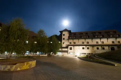 a building at night with the moon behind it at Guesthouse Junior in Kopaonik