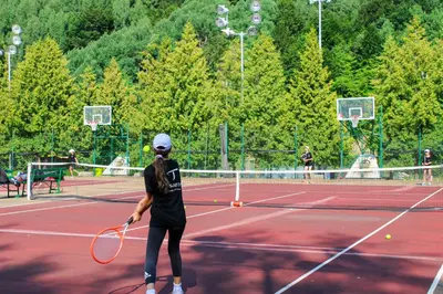 a woman playing tennis on a tennis court at Guesthouse Junior in Kopaonik