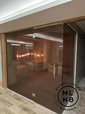a glass door in a room with a fireplace at Milmari Lux N8 in Kopaonik