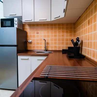 a kitchen with white cabinets and a stainless steel refrigerator at Godimento Vrnjačka Banja in Vrnjačka Banja