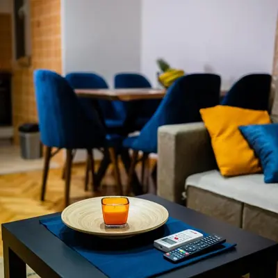 a glass of orange juice on a plate on a table at Godimento Vrnjačka Banja in Vrnjačka Banja