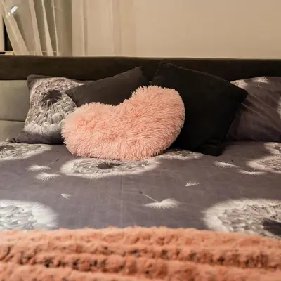 a pink heart pillow on a bed with pillows at Godimento Vrnjačka Banja in Vrnjačka Banja