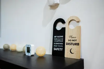 a black table with a phone and a sign on it at Godimento Vrnjačka Banja in Vrnjačka Banja