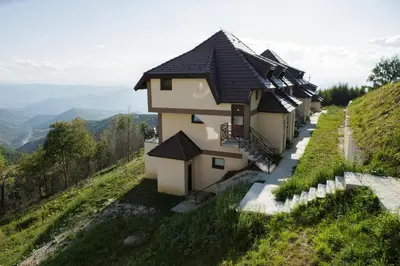a row of houses on the side of a hill at Dvori Sky View E14 Kopaonik - free private parking in Kopaonik