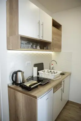 a kitchen with white cabinets and a counter with a sink at Dvori Sky View E14 Kopaonik - free private parking in Kopaonik