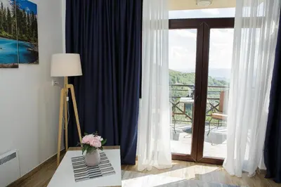 a room with a table with a vase of flowers on it at Dvori Sky View E14 Kopaonik - free private parking in Kopaonik