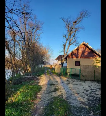 a dirt road next to a house and a fence at Radetov konak in Ðunis