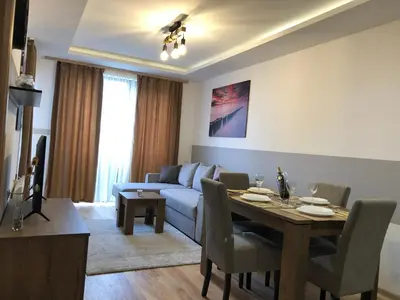 a living room with a table and a couch at Vila Planinsko Blago Luxury Apartmans in Kopaonik