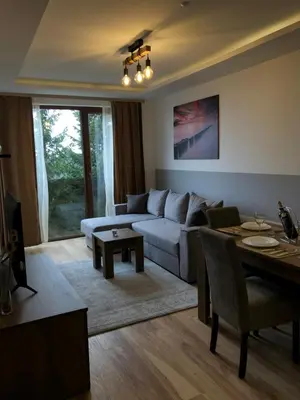 a living room with a couch and a table at Vila Planinsko Blago Luxury Apartmans in Kopaonik
