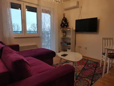 a living room with a purple couch and a table at Bellavista in Vrnjačka Banja