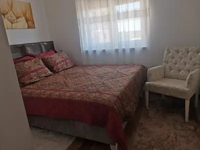 a bedroom with a bed and a chair at Bellavista in Vrnjačka Banja