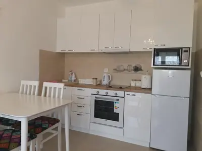 a kitchen with white appliances and a table with chairs at Bellavista in Vrnjačka Banja