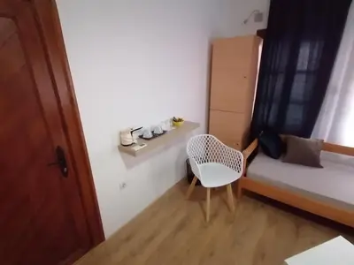 a small room with a bed and a chair at MON Accommodation free parking in Niš