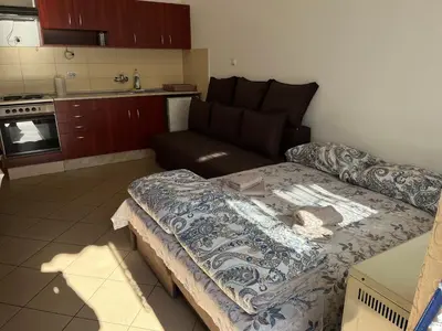 a living room with a couch and a kitchen at Mladenović smeštaj in Soko Banja