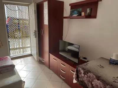 a living room with a tv and a bedroom at Mladenović smeštaj in Soko Banja