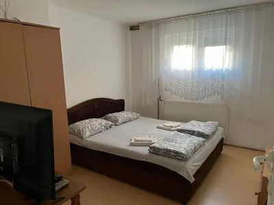 a small bedroom with a bed and a television at Smestaj Miki in Soko Banja