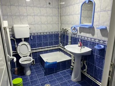 a blue tiled bathroom with a toilet and a sink at Smestaj Miki in Soko Banja