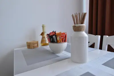 a table with a white vase and a bowl of sticks at Lux Pegaz 008 in Vrnjačka Banja