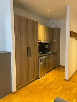 an empty kitchen with wooden cabinets and a refrigerator at BRZECE SKI GONDOLA & FREE PARKING apartment in Kopaonik