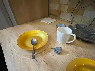 a yellow plate and a spoon on a table at Apartman Pahuljica in Kopaonik