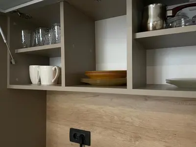 a kitchen cabinet with plates and cups and bowls at Apartman Pahuljica in Kopaonik