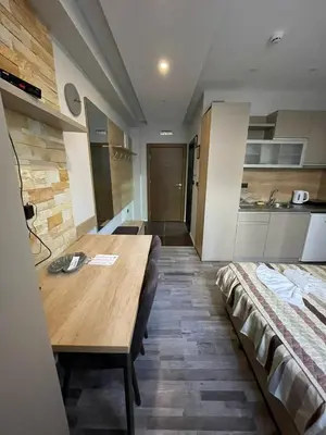 a room with a table and a bed in it at Apartman Pahuljica in Kopaonik