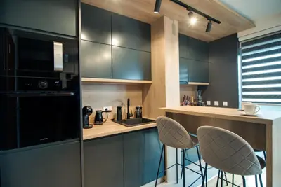 a kitchen with two bar stools and a counter at IN LUX SPA APARTMAN in Vrnjačka Banja