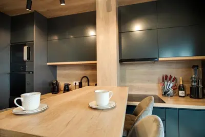 a kitchen with a wooden table with two cups on it at IN LUX SPA APARTMAN in Vrnjačka Banja