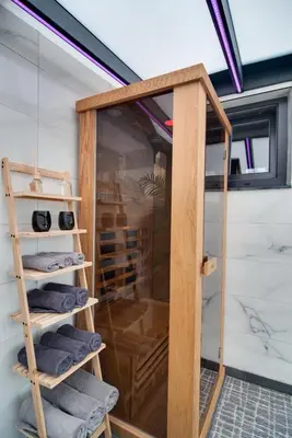 a shower room with a glass door and towels at IN LUX SPA APARTMAN in Vrnjačka Banja