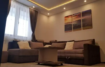 a living room with a couch and a table at WELLKOP Apartman Kopaonik in Kopaonik