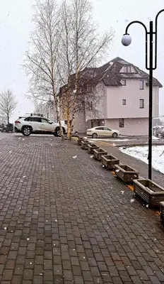 a parking lot with benches and a street light at WELLKOP Apartman Kopaonik in Kopaonik