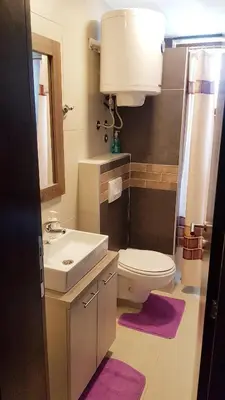 a bathroom with a sink and a toilet and a mirror at WELLKOP Apartman Kopaonik in Kopaonik