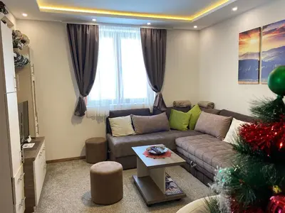 a living room with a couch and a christmas tree at WELLKOP Apartman Kopaonik in Kopaonik