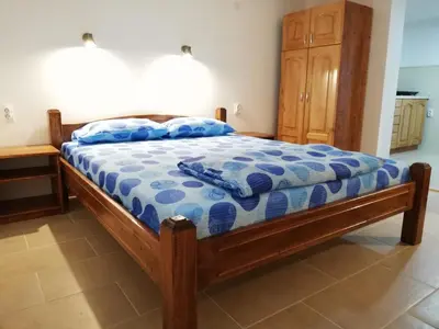 a bedroom with a bed with a blue comforter at Sobe i apartmani Simic in Ribarska Banja