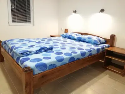 a bed with a blue and white comforter on it at Sobe i apartmani Simic in Ribarska Banja