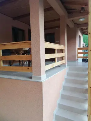 a porch with stairs and a wooden fence at Sobe i apartmani Simic in Ribarska Banja