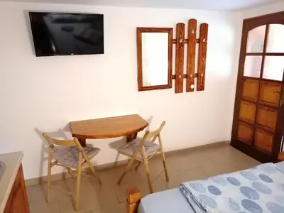 a room with a table and two chairs and a television at Sobe i apartmani Simic in Ribarska Banja