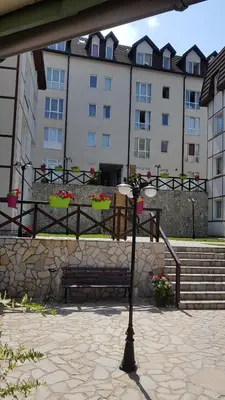 a bench in front of a building with some flowers at Čar30 Kraljevi čardaci in Kopaonik